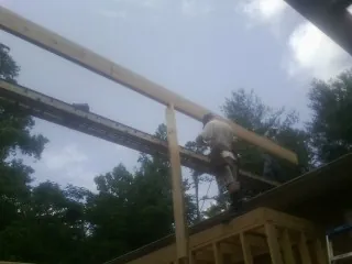 Carpenter setting a ridge beam over a new addition frame — Ice Dam Removal by Roofing Brothers in Corvallis