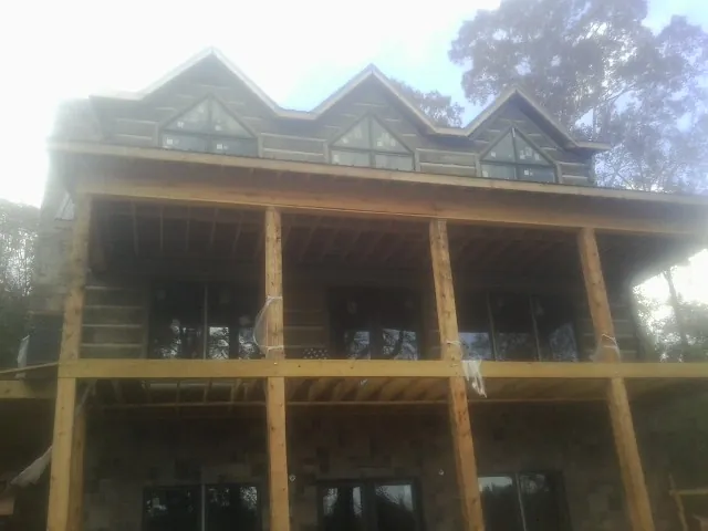 Dormers and porch framing on a large log home under construction — Roof Coating work by our crew in Corvallis